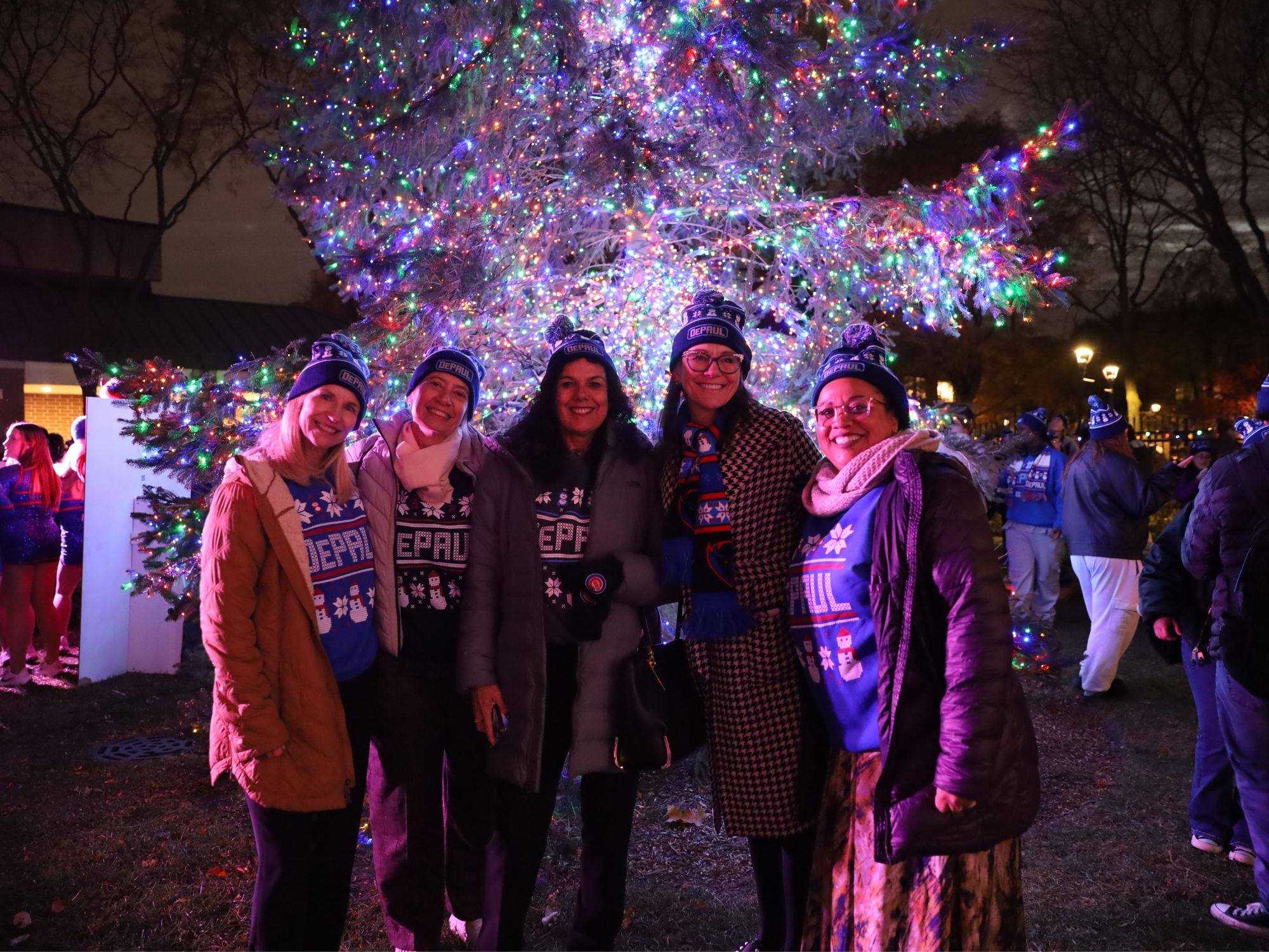A group poses in front of a Christmas tree